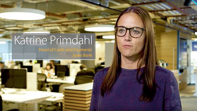 Woman named Katrine Primdahl, Head of Cards and Payments at JSKYE Bank, talks to the camera in an office space. 
