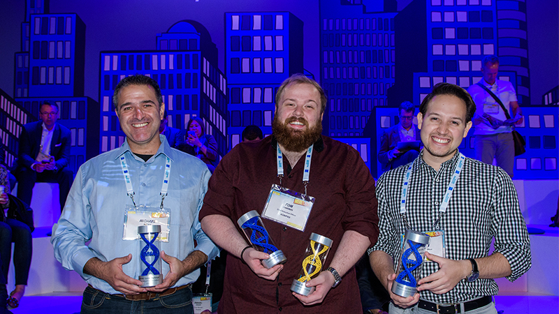 Three men pose with their trophies after winning the Visa Everywhere Initiative competition in Europe. 