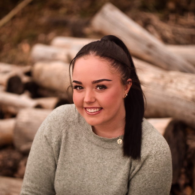 Woman sitting on woodpile