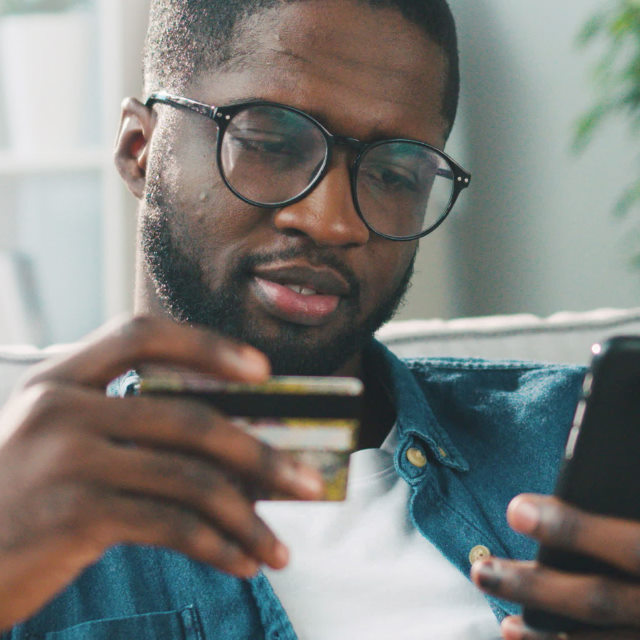 Person holding card while looking at phone